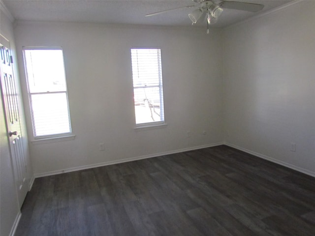 spare room featuring dark wood-style floors, baseboards, a wealth of natural light, and a ceiling fan