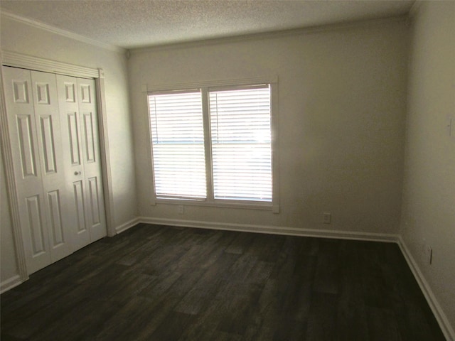 unfurnished bedroom with a textured ceiling, dark wood-type flooring, a closet, and baseboards