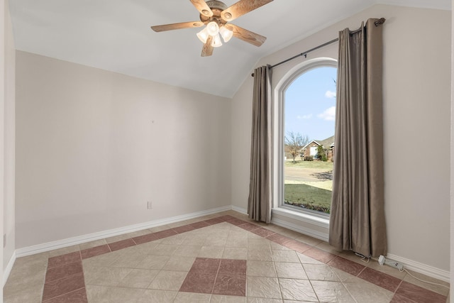 empty room featuring lofted ceiling, light tile patterned floors, ceiling fan, and baseboards