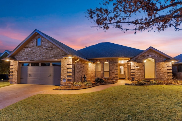 view of front of property featuring an attached garage, brick siding, driveway, roof with shingles, and a front lawn