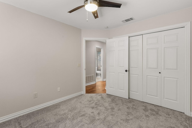 unfurnished bedroom with a closet, carpet, visible vents, and baseboards