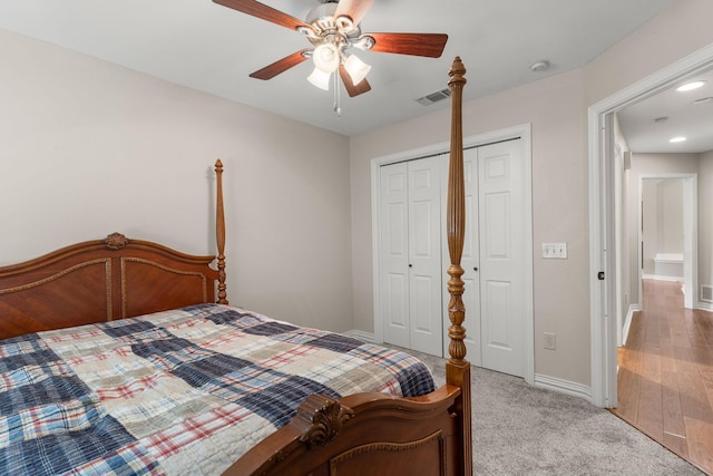 bedroom with light carpet, visible vents, baseboards, a ceiling fan, and a closet