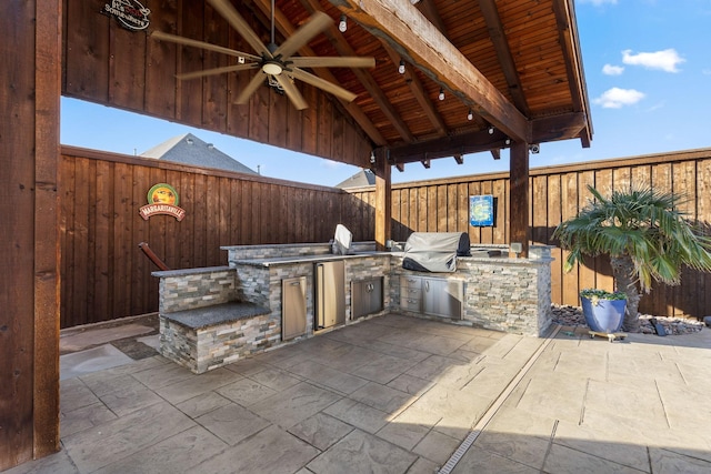 view of patio with a fenced backyard, grilling area, exterior kitchen, and a gazebo