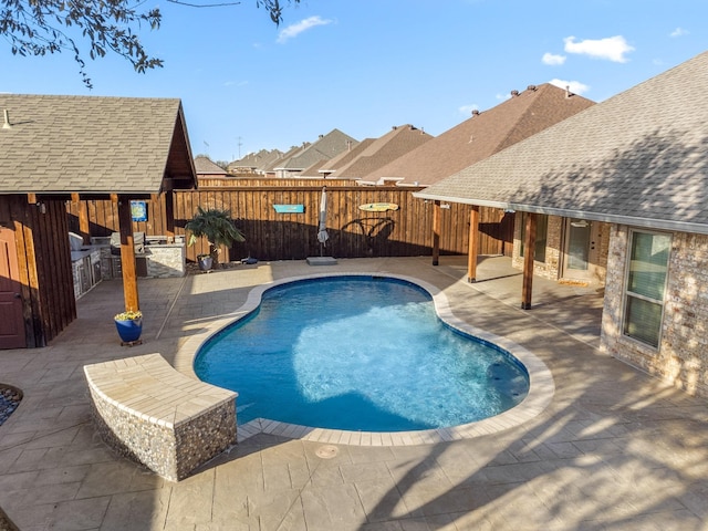 view of pool featuring a fenced in pool, a patio area, fence, and exterior kitchen