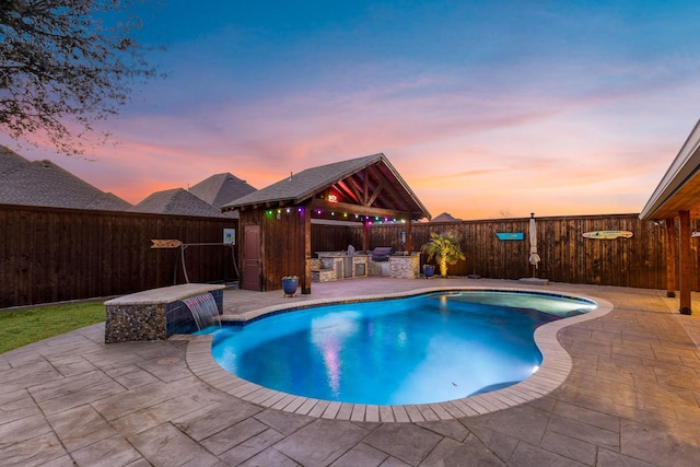 view of swimming pool featuring an outdoor kitchen, a fenced backyard, outdoor dry bar, a gazebo, and a patio area