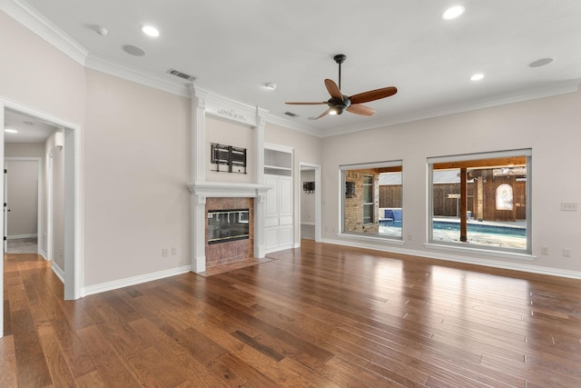 unfurnished living room with crown molding, a fireplace, visible vents, hardwood / wood-style floors, and baseboards