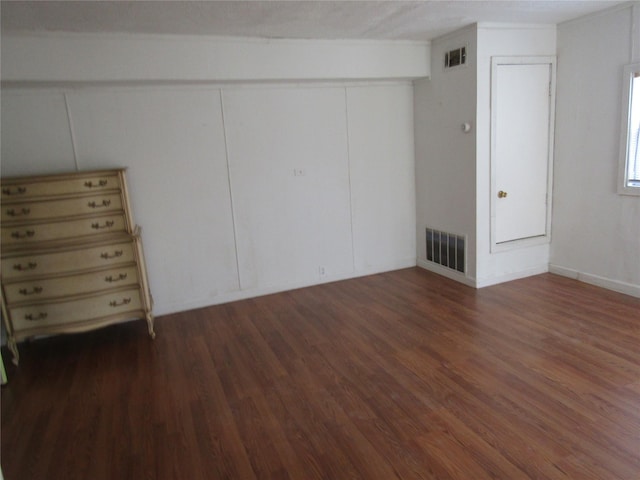 unfurnished bedroom with a closet, visible vents, and wood finished floors