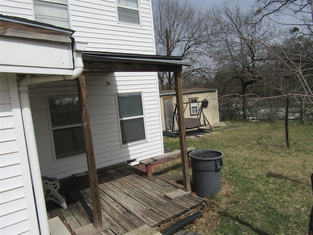 view of home's exterior with a deck, a yard, and fence