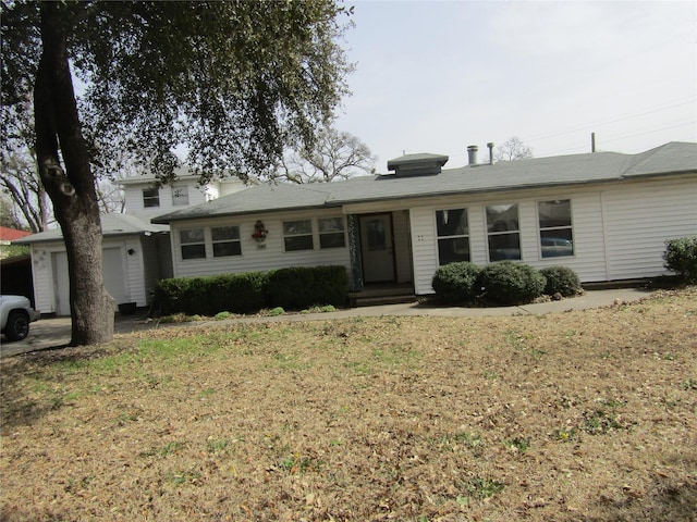 ranch-style home with a garage and a front lawn