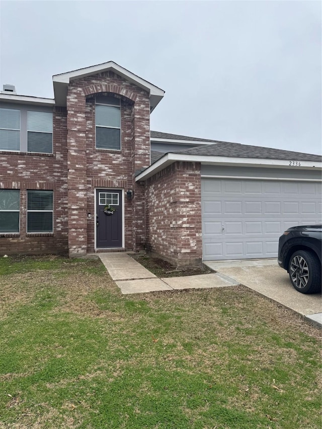 traditional home with a garage, driveway, a front lawn, and brick siding