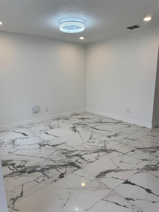 empty room featuring a textured ceiling, recessed lighting, visible vents, and baseboards