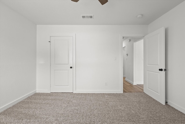 unfurnished bedroom featuring a ceiling fan, carpet, visible vents, and baseboards