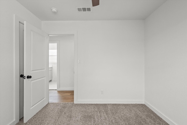 unfurnished room featuring visible vents, baseboards, a ceiling fan, and carpet flooring