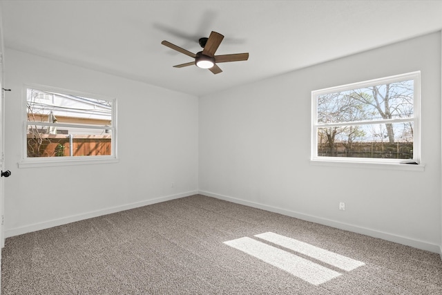 empty room featuring carpet flooring, plenty of natural light, and baseboards