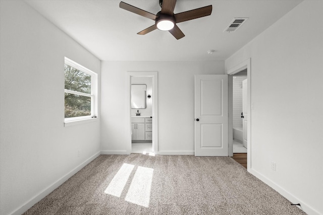 unfurnished bedroom with a ceiling fan, baseboards, visible vents, carpet floors, and connected bathroom