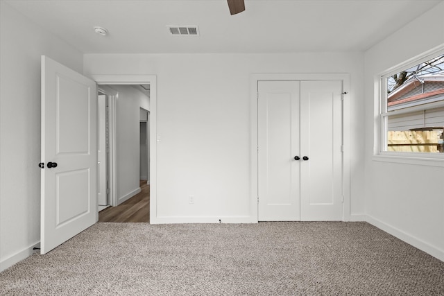 unfurnished bedroom featuring visible vents, baseboards, a closet, and carpet flooring