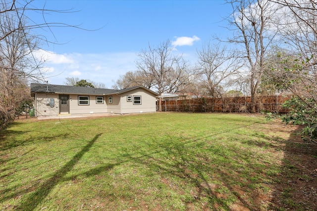 rear view of property with a patio area, a yard, and fence