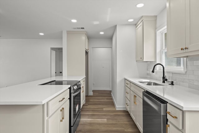 kitchen featuring a sink, wood finished floors, stainless steel appliances, light countertops, and decorative backsplash