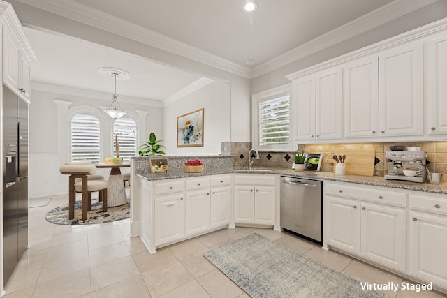 kitchen with appliances with stainless steel finishes, crown molding, a sink, and white cabinetry