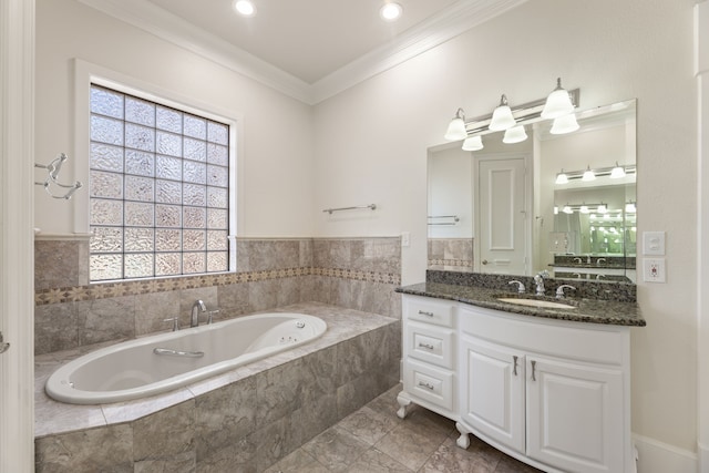 bathroom with ornamental molding, a garden tub, and vanity