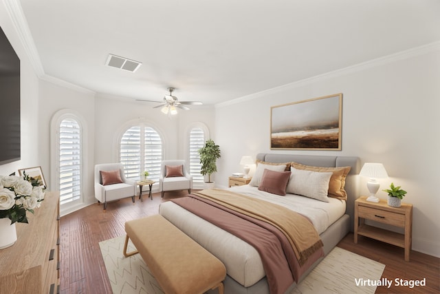 bedroom with crown molding, visible vents, ceiling fan, wood finished floors, and baseboards