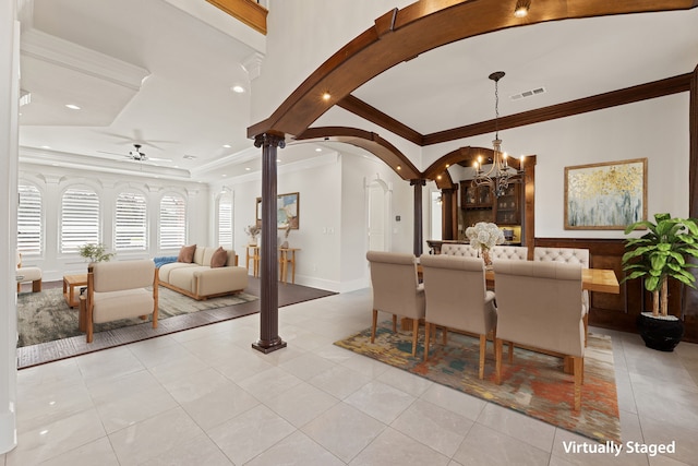 dining room with decorative columns, visible vents, arched walkways, crown molding, and ceiling fan with notable chandelier