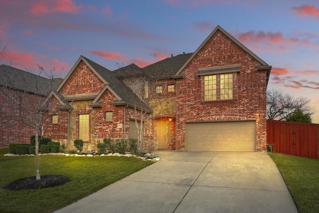 view of front facade with a garage, brick siding, concrete driveway, fence, and a front yard