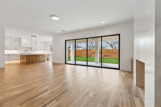 unfurnished living room with light wood-style floors, baseboards, and recessed lighting