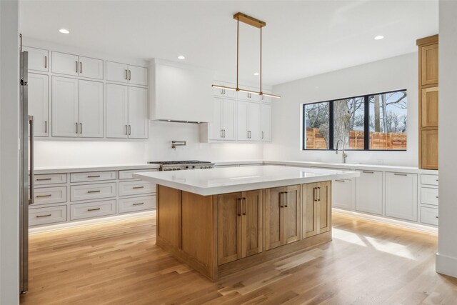 kitchen featuring light countertops, custom exhaust hood, and white cabinets