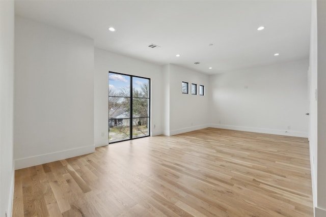 unfurnished room featuring light wood-type flooring, visible vents, baseboards, and recessed lighting