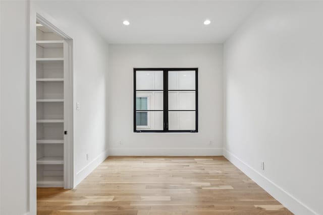 empty room featuring light wood-type flooring, baseboards, and recessed lighting