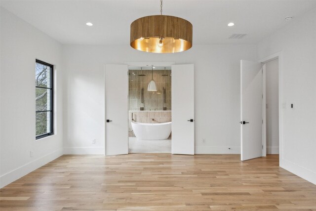 empty room featuring recessed lighting, baseboards, visible vents, and light wood finished floors