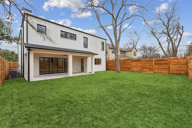 back of house with a patio, a lawn, and a fenced backyard