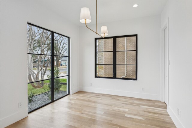 empty room featuring recessed lighting, light wood-style flooring, and baseboards