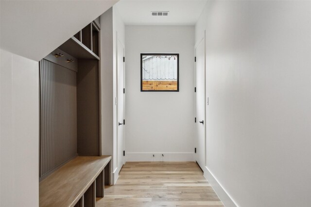 mudroom featuring light wood finished floors, visible vents, and baseboards