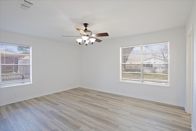 empty room with light wood-style floors, baseboards, and a ceiling fan