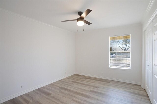 unfurnished bedroom featuring ornamental molding, a closet, light wood-style flooring, and baseboards