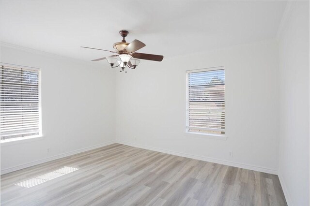 unfurnished room with light wood-type flooring, a ceiling fan, and baseboards