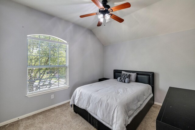 bedroom with a ceiling fan, carpet, lofted ceiling, and baseboards