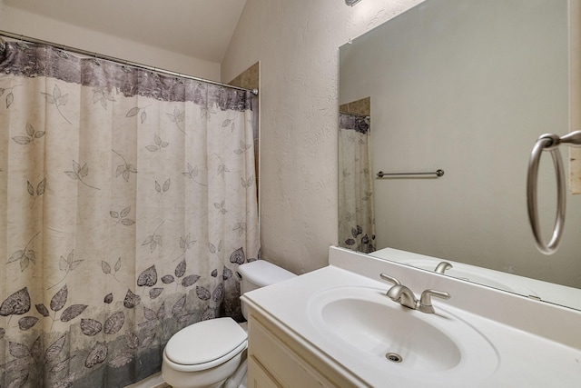 bathroom featuring a shower with curtain, a textured wall, vanity, and toilet