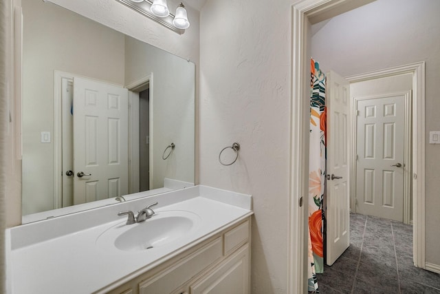 bathroom featuring a textured wall, tile patterned flooring, and vanity