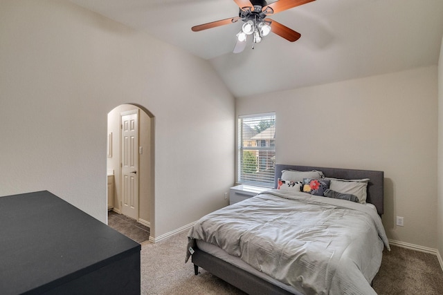 carpeted bedroom with arched walkways, ceiling fan, vaulted ceiling, and baseboards