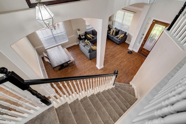 stairway featuring baseboards, arched walkways, and a chandelier