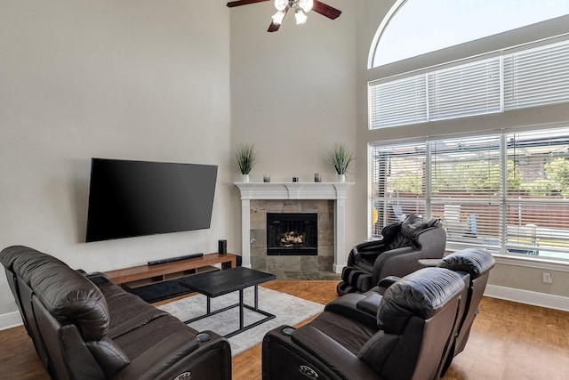 living area featuring a tile fireplace, plenty of natural light, and wood finished floors