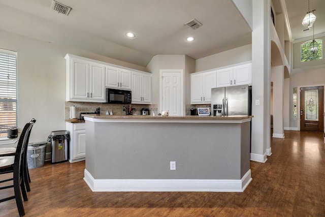 kitchen with black microwave, visible vents, stainless steel fridge with ice dispenser, and white cabinetry