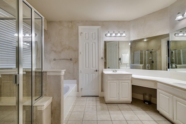 full bathroom with a garden tub, double vanity, a sink, a shower stall, and tile patterned floors