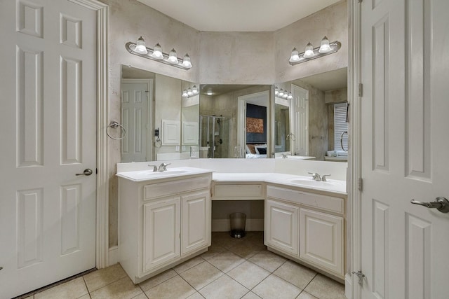 full bath with a stall shower, double vanity, a sink, and tile patterned floors