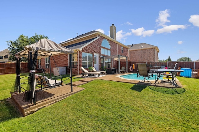 back of property featuring a patio area, brick siding, a yard, and a fenced backyard