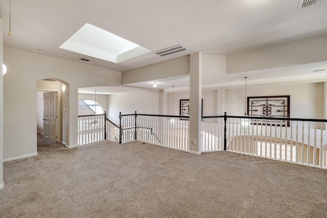 unfurnished room featuring carpet, visible vents, and a notable chandelier