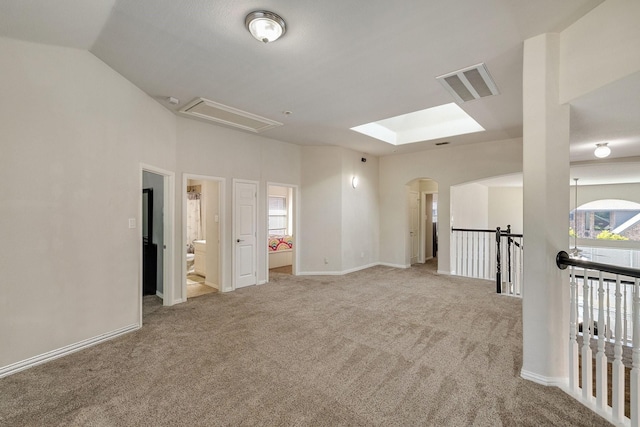 carpeted empty room featuring lofted ceiling, visible vents, and baseboards